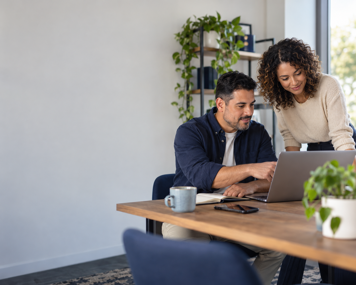 Two small-business colleagues reviewing operations together at a laptop.